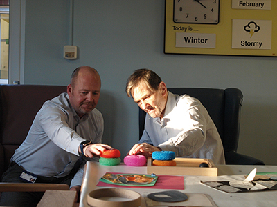 A user and a consultant interact with objects during a workshop